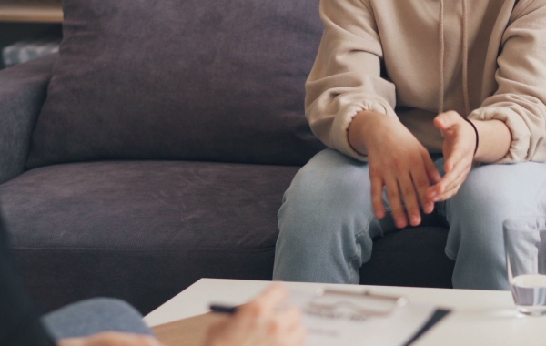 close up photo of someone sitting on a couch talking to a therapist in toronto