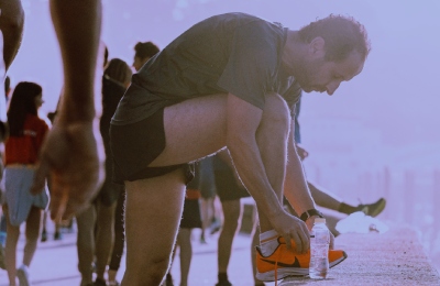a runner stopping to tie his shoes during a race